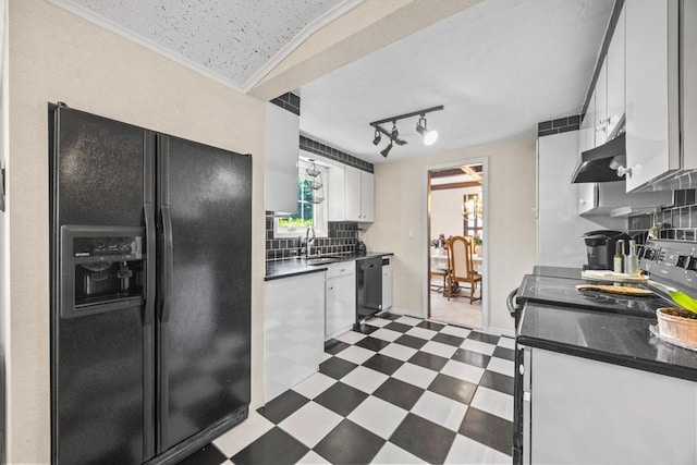 kitchen with black appliances, dark floors, under cabinet range hood, dark countertops, and a sink