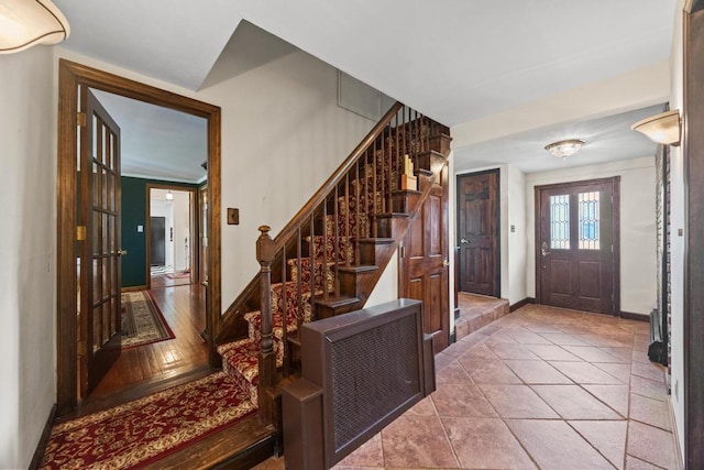 foyer entrance with baseboards and stairs