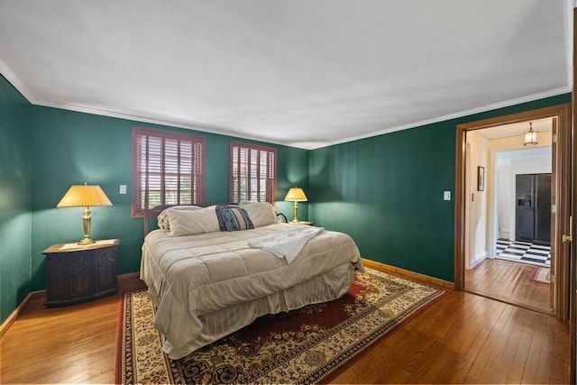 bedroom with wood-type flooring, baseboards, and ornamental molding