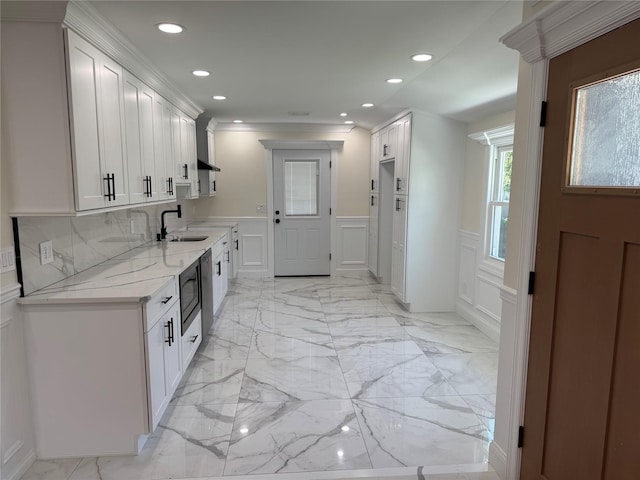 9 Henry St, Wyandanch, NY 11798 - kitchen with a decorative wall, a sink, a wainscoted wall, white cabinetry, and recessed lighting