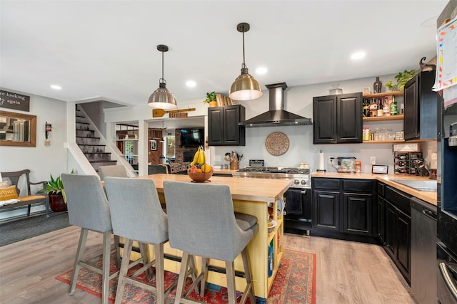 45 Proctor Rd, Eldred, NY 12732 - kitchen featuring wall chimney range hood, stainless steel appliances, butcher block counters, open shelves, and a kitchen bar