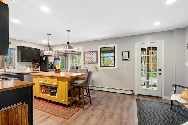 45 Proctor Rd, Eldred, NY 12732 - kitchen with butcher block counters, a baseboard heating unit, black fridge, a sink, and healthy amount of natural light