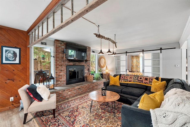 45 Proctor Rd, Eldred, NY 12732 - living room featuring wood finished floors, wood walls, a barn door, and a brick fireplace