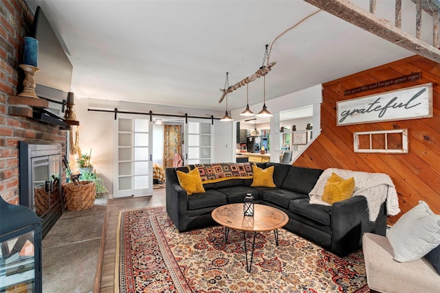 45 Proctor Rd, Eldred, NY 12732 - living room with a barn door, wood walls, and a fireplace
