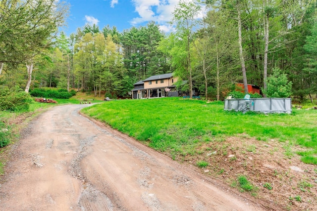 45 Proctor Rd, Eldred, NY 12732 - view of grassy yard with dirt driveway, a forest view, and an outdoor pool