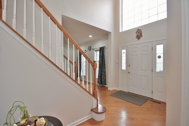 622 Creekside Ln, Fishkill, NY 12524 - entryway featuring light wood-style flooring, a towering ceiling, stairway, baseboards, and ornamental molding