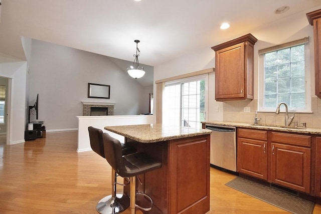 622 Creekside Ln, Fishkill, NY 12524 - kitchen featuring a sink, dishwasher, light wood-style flooring, a kitchen island, and a brick fireplace