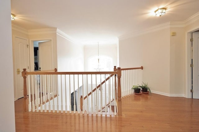622 Creekside Ln, Fishkill, NY 12524 - corridor featuring wood finished floors, a chandelier, ornamental molding, baseboards, and an upstairs landing