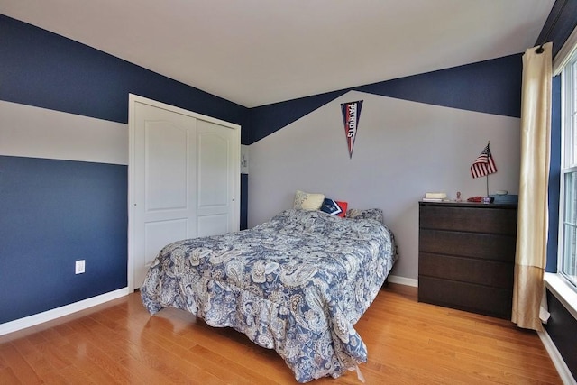 622 Creekside Ln, Fishkill, NY 12524 - bedroom featuring wood finished floors, a closet, baseboards, multiple windows, and vaulted ceiling