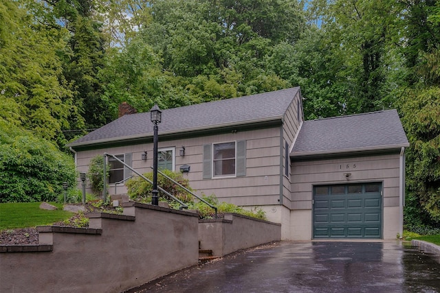 155 Woodbury Rd, Huntington, NY 11743 - view of front of property with driveway, an attached garage, a shingled roof, and a chimney