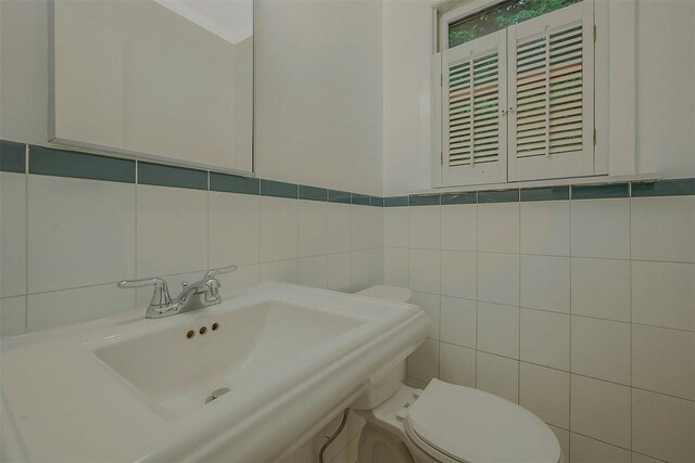 155 Woodbury Rd, Huntington, NY 11743 - bathroom featuring tile walls, a sink, toilet, and crown molding
