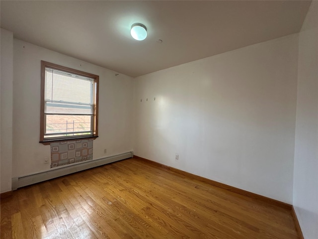 7177 159th St Unit 205, Flushing, NY 11365 - spare room with a baseboard radiator, light wood-style floors, and baseboards