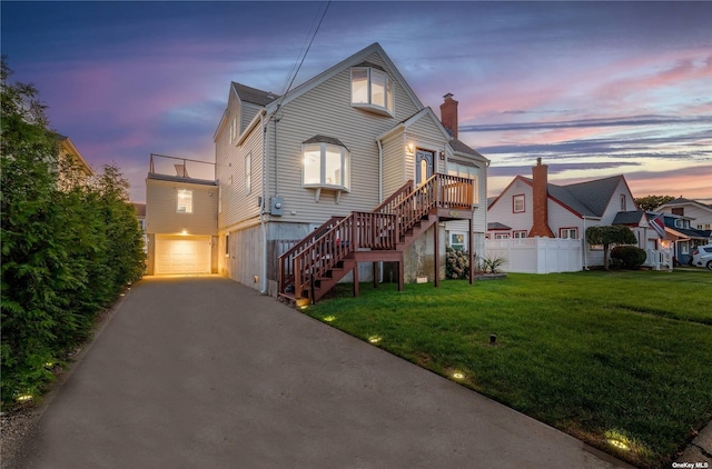 view of front of home with a garage, stairs, a chimney, and driveway