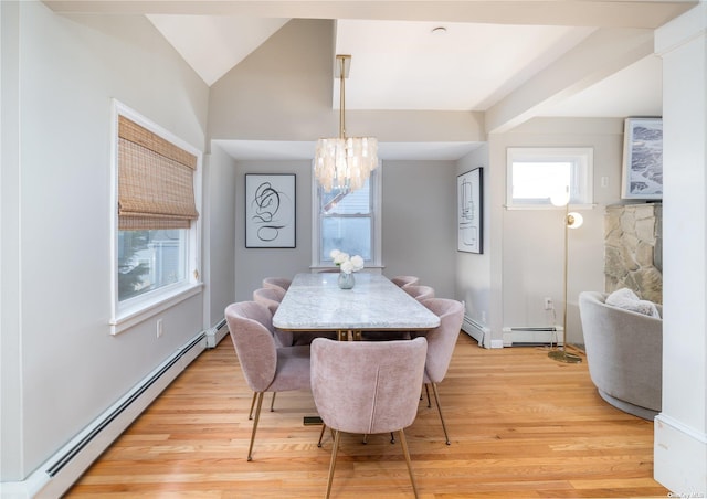 dining space featuring baseboard heating, a chandelier, light wood-style floors, and vaulted ceiling
