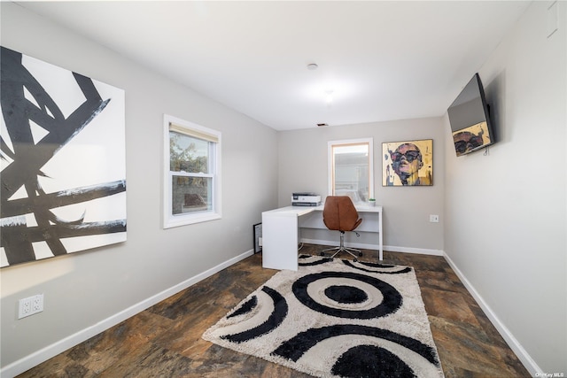 office space featuring dark stone finish floors and baseboards