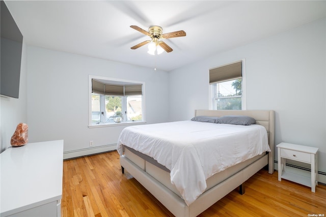 bedroom with a baseboard radiator, light wood-type flooring, and ceiling fan