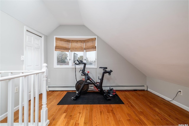 workout room with a baseboard radiator, wood finished floors, lofted ceiling, and baseboards