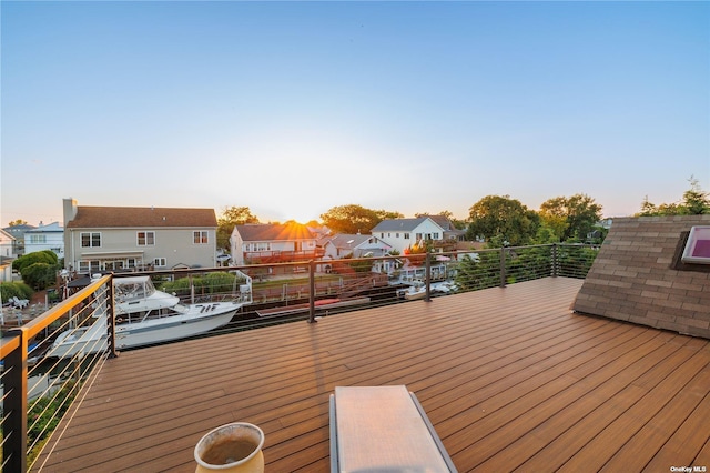 deck at dusk featuring a residential view and a boat dock