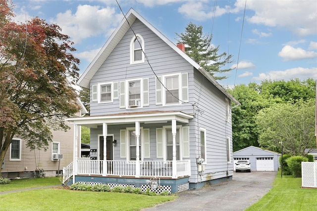 american foursquare style home featuring covered porch, an outdoor structure, a chimney, and a front yard