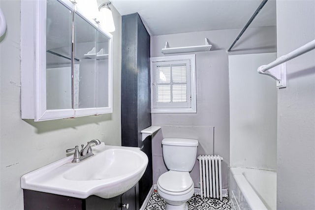 full bath with radiator heating unit, toilet, vanity, and tile patterned floors