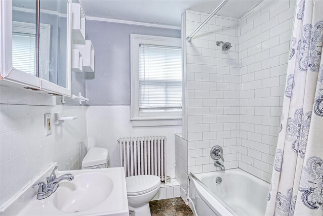 bathroom with radiator heating unit, a sink, toilet, shower / tub combo, and tile walls