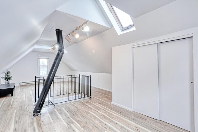 bonus room featuring a skylight, vaulted ceiling, wood finished floors, and baseboards