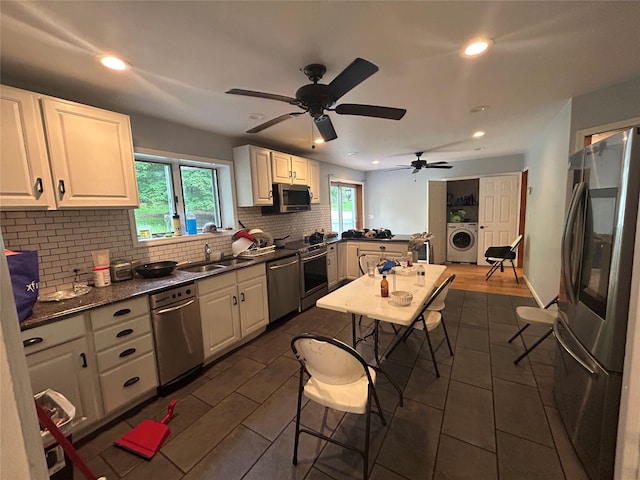 1433 Rte 208, Washingtonville, NY 10992 - kitchen featuring stainless steel appliances, washer / dryer, a sink, backsplash, and white cabinetry