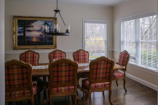 dining room with wood finished floors, baseboards, and ornamental molding
