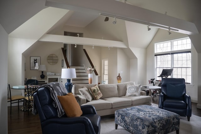 living area with rail lighting, wood finished floors, vaulted ceiling, and baseboards