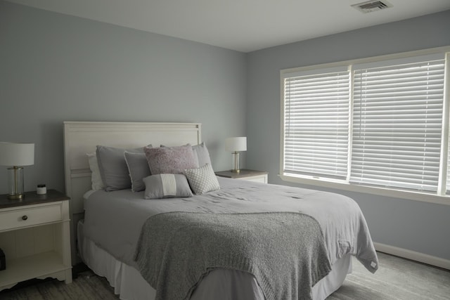 bedroom featuring baseboards and multiple windows