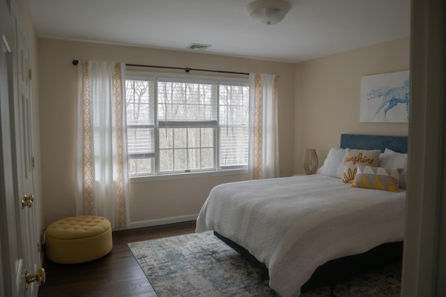 bedroom with baseboards and wood finished floors