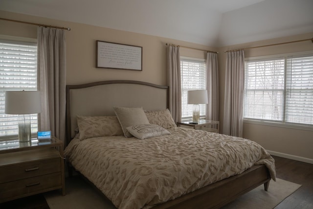 bedroom featuring wood finished floors, baseboards, and lofted ceiling