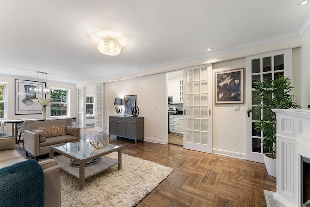 living area featuring baseboards, ornamental molding, a chandelier, recessed lighting, and french doors