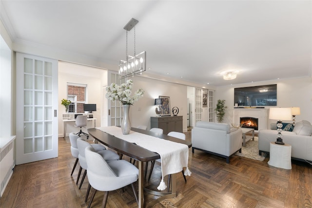 dining area with a warm lit fireplace, ornamental molding, and recessed lighting