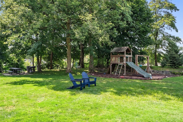 view of green lawn with a playground and view of scattered trees