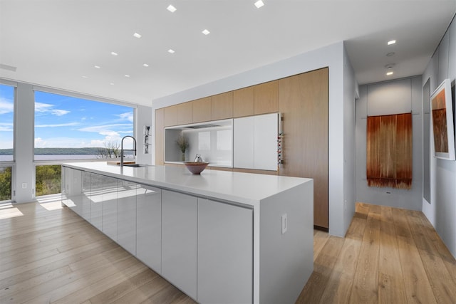 26 Mount Green Rd, Croton-On-Hudson, NY 10520 - kitchen featuring a sink, a kitchen island with sink, modern cabinets, light wood finished floors, and light countertops