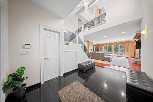 9 Fairwind Ct, Oakdale, NY 11769 - foyer with granite tiled floors, a high ceiling, stairway, and baseboards