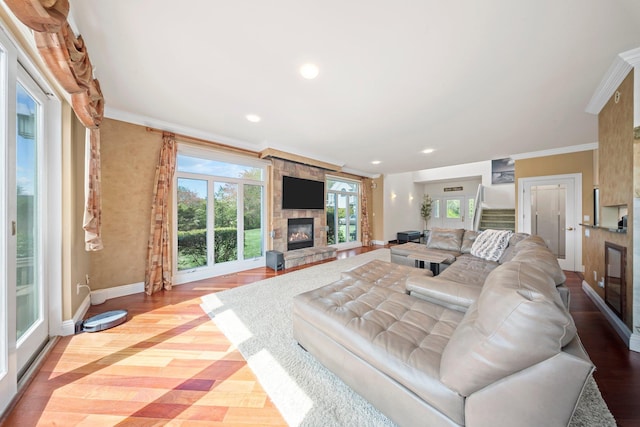 9 Fairwind Ct, Oakdale, NY 11769 - living room with a stone fireplace, baseboards, wood finished floors, crown molding, and recessed lighting