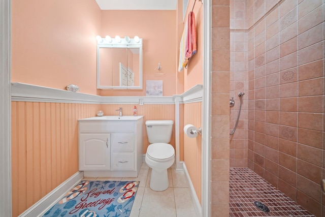 9 Fairwind Ct, Oakdale, NY 11769 - bathroom with wainscoting, tiled shower, toilet, vanity, and tile patterned flooring