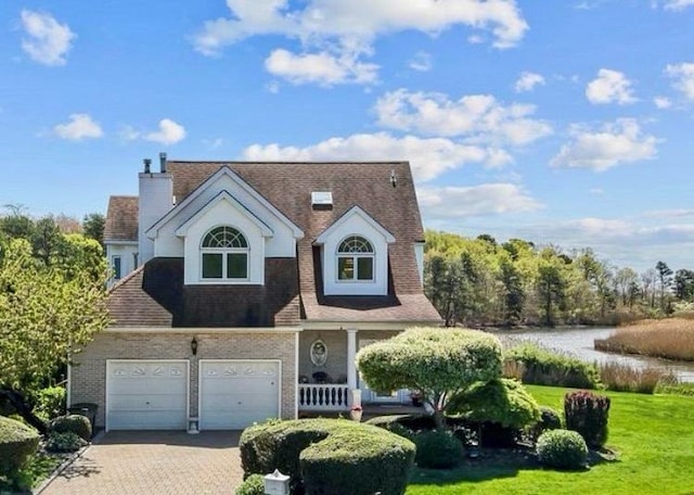9 Fairwind Ct, Oakdale, NY 11769 - view of front of home featuring driveway, a front yard, brick siding, a water view, and a porch