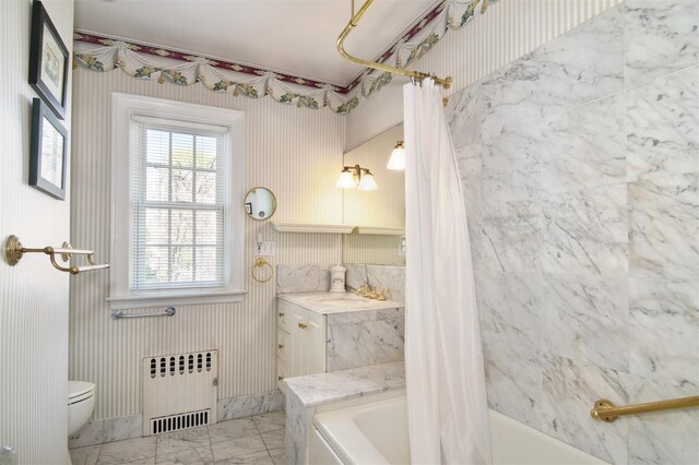 full bath featuring radiator heating unit, shower / tub combo, toilet, marble finish floors, and wallpapered walls