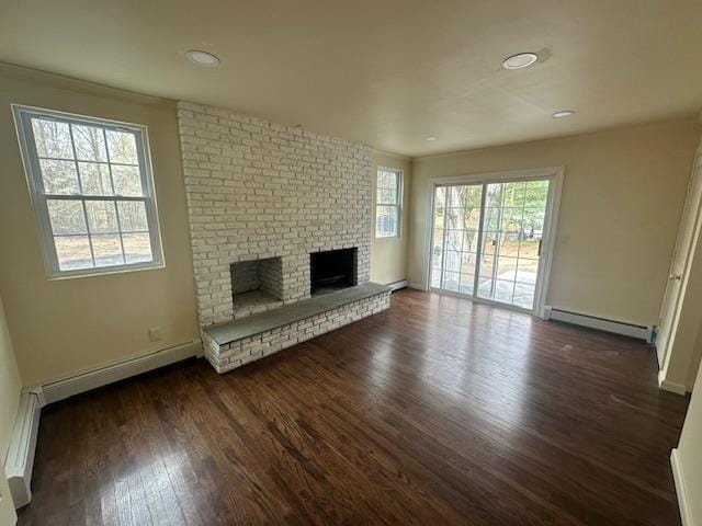 unfurnished living room featuring baseboard heating, dark wood-style flooring, a fireplace, and baseboards