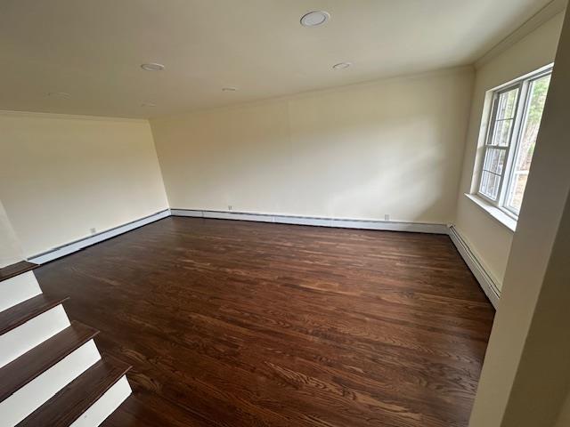 unfurnished room featuring a baseboard heating unit, ornamental molding, wood finished floors, baseboards, and recessed lighting