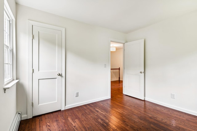8 Mill Lot Rd, Middle Island, NY 11953 - unfurnished bedroom with baseboard heating, wood finished floors, and baseboards