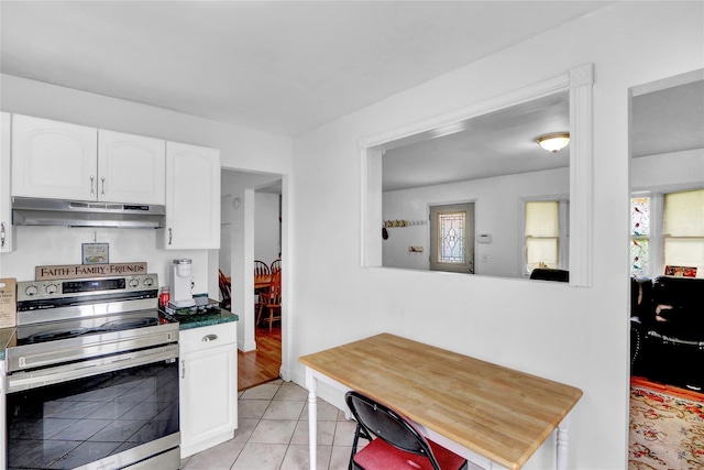 24 Haynes Ave, West Islip, NY 11795 - kitchen featuring under cabinet range hood, stainless steel electric range, white cabinetry, light tile patterned floors, and dark countertops