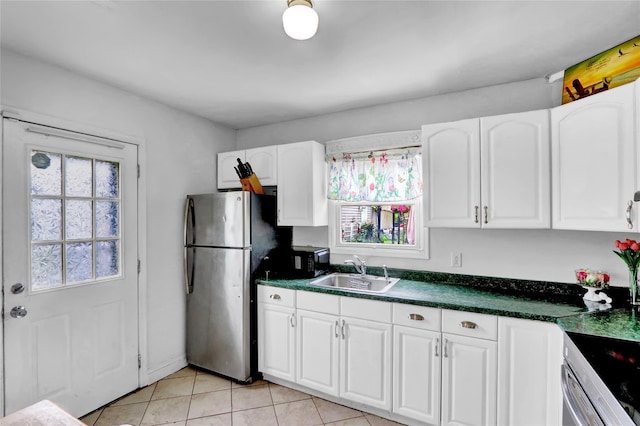 24 Haynes Ave, West Islip, NY 11795 - kitchen with a sink, freestanding refrigerator, white cabinetry, dark countertops, and light tile patterned flooring