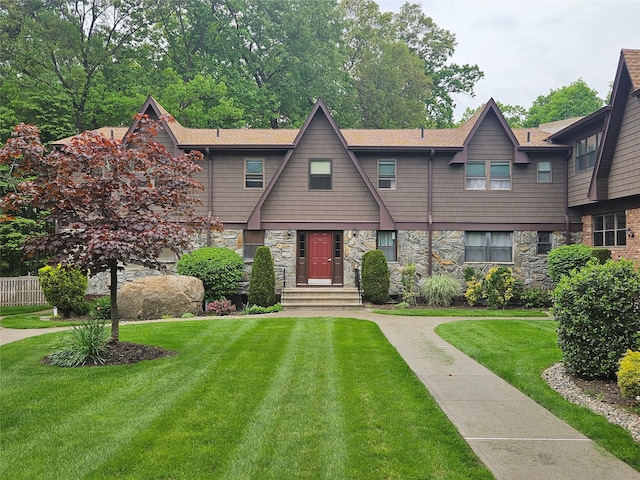 view of front of home with stone siding and a front lawn