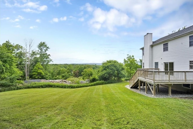view of green lawn featuring a deck and stairs