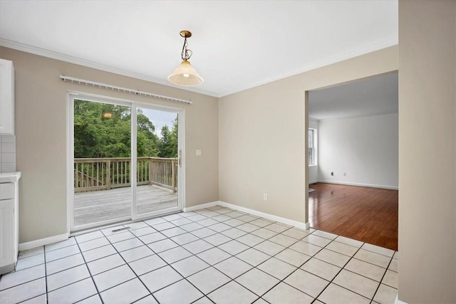 spare room featuring crown molding, baseboards, and light tile patterned flooring