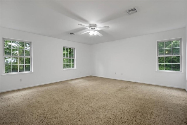 unfurnished room featuring a ceiling fan, healthy amount of natural light, carpet flooring, and baseboards